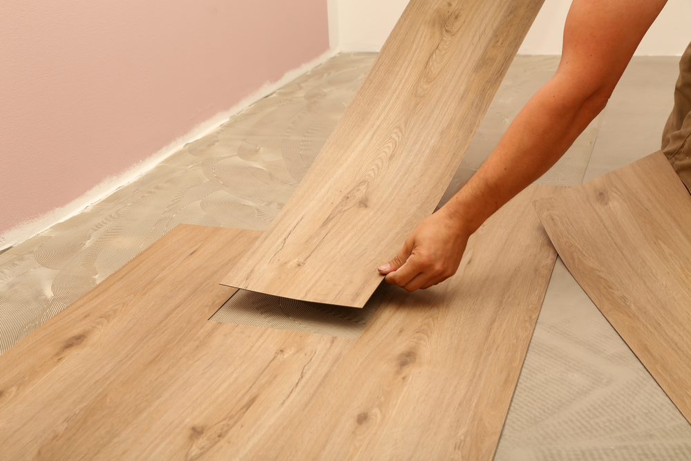Worker installing vinyl flooring
