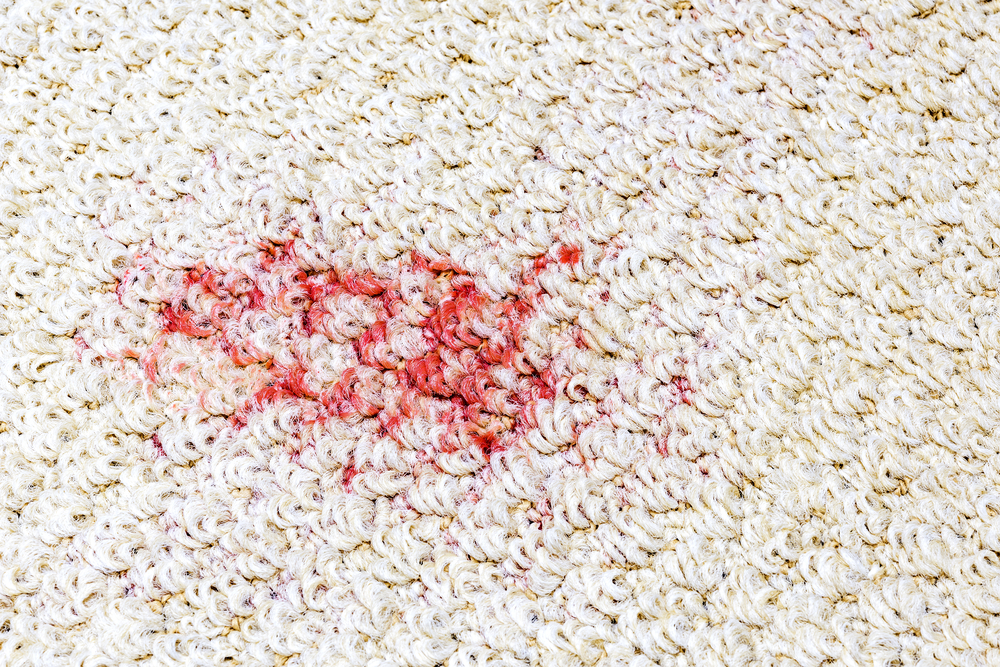 a red stain from a spill on a carpet