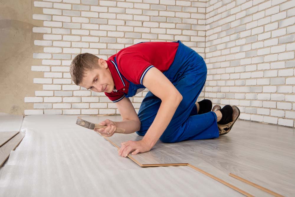 a contractor replacing laminate floor boards