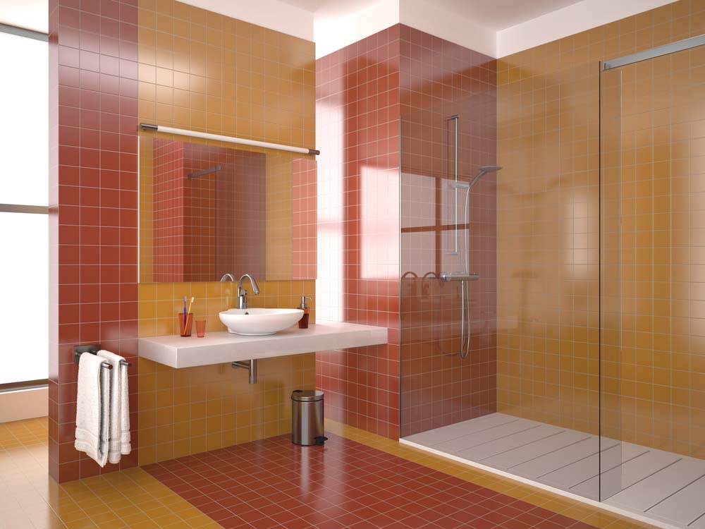 A bathroom with muted red and orange tiles along the floor and walls.
