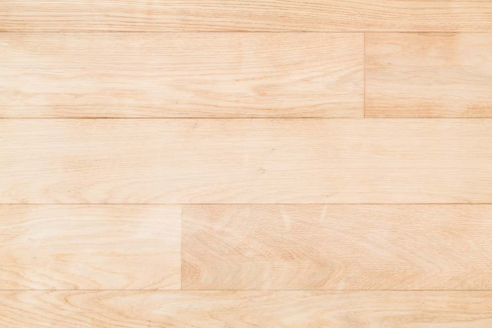 A close-up of very pale hardwood floors.